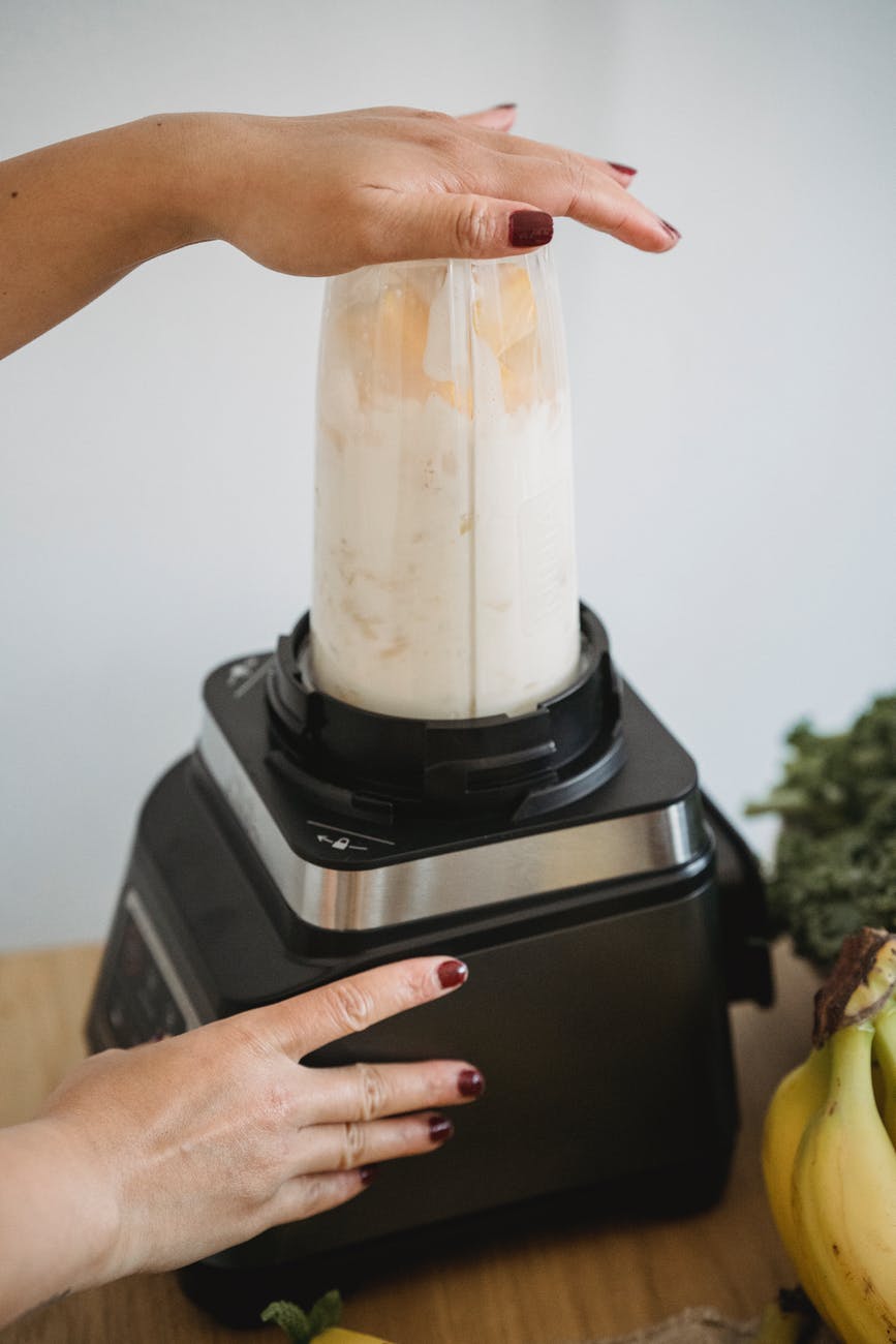 a person making smoothie using blender